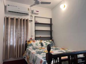 a small bedroom with a bed and a window at Varma Brick House in Manipal
