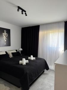 a bedroom with a black bed with two white pillows at Apartamenty Cegielnia 1 Lux-Haus in Gorzów Wielkopolski