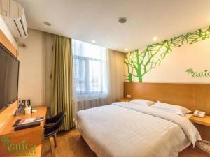 a hotel room with a bed and a desk and a television at Vatica TianJin NanKai Hardware Market West JieYuan Road Hotel in Tianjin