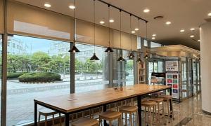 um restaurante com uma grande mesa de madeira e cadeiras em Busan Metropolitan City Corporation's Arpina em Busan