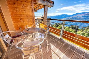 einen Balkon mit einem Tisch und Stühlen auf einer Hütte in der Unterkunft Résidence L'ecrin - ECRIN A22 MAE-0131 in Arc 1800