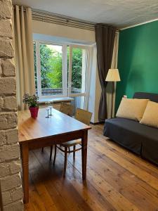a living room with a table and a bed at Barinu Street Apartment in Liepāja