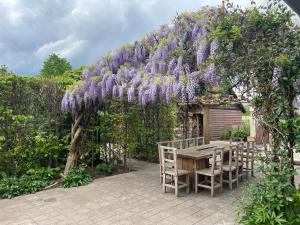 a pergola with a table and chairs under it at Het Wolvennest in Maasmechelen +7 photos
