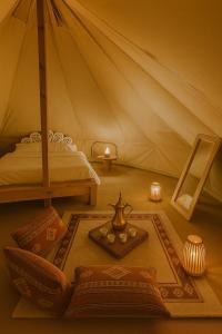a room with a bed and a tent with a table at Bidiyah Old Bedouin Wahaiba Desert CAMP in Badīyah +37 photos