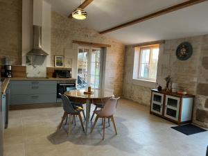 a kitchen with a table and chairs in a room at Gîte Le Ptit Poirier in Coulon