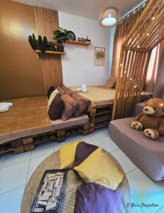 1 dormitorio con 2 camas y un osito de peluche en El Nissi Staycation, FAMILY CABIN, CONTEMPORARY CABIN, Enchanted Kingdom, en Santa Rosa 27 fotos más