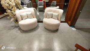 two white chairs with pillows in a salon at Hotel Star Islamabad in Islamabad