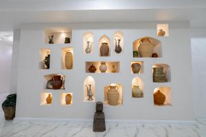 a display of vases and other items on a wall in a museum at Potter Hotel Khiva in Khiva