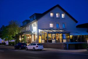 a building with a white car parked in front of it at Landgasthaus Hotel H. Kortlüke in Belm