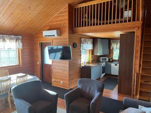 a living room with a television and a kitchen at Kärpänrinne A in Syöte