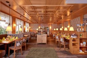 a restaurant with wooden floors and tables and chairs at Landgasthaus Hotel H. Kortlüke in Belm