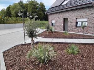 a garden with plants in front of a building at Neue Welt Ferienwohnung 1 in Osteel