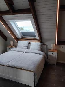 a bedroom with a large bed with a window at Neue Welt Ferienwohnung 1 in Osteel