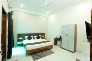 a bedroom with a bed and a television in it at Shri Raghav Palace I Hotel In Ayodhya in Ayodhya