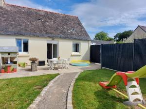 a backyard with a play area and a house at Jolie maison proche commodités, idéal vacances ou professionnels in Pleyben