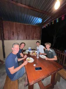 a group of people sitting at a table eating food at Haris Homestay & Cottages in Senaru