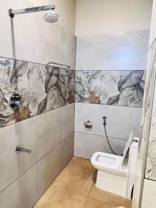 a bathroom with a toilet and a shower at Dwaraka Resorts in Tiruvannāmalai