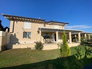 a white house with a patio and a yard at Villa Sabina in Lido di Camaiore