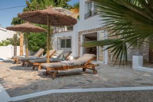 a row of lounge chairs and umbrellas in front of a building at Casa Cobalto, Sea view, Mediterranean, Sea 700meters, 4 Bedrooms in Benissa