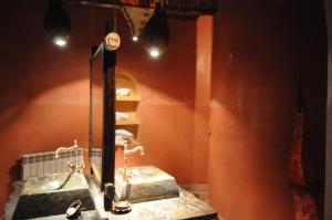 a bathroom with a sink and a mirror at Kasbah Hotel Tombouctou in Merzouga
