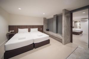 a bedroom with a large bed and a bathroom at Grand Alpine Hotel in Bangkok