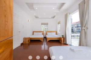 a living room with two beds and a window at Villas Checkin Hoa Giấy Gần Tháp Tam Thắng Bãi Sau in Vung Tau +33 photos