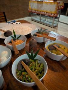 a wooden table with bowls of food on it at Undiya The Neighborhood Sigiriya in Sigiriya +13 photos