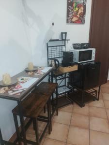 a dining room with two tables and a microwave at Monreale Prestige Rooms B&B in Monreale