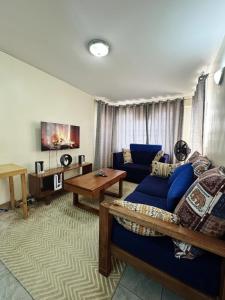 ein Wohnzimmer mit einem blauen Sofa und einem Tisch in der Unterkunft Ikulu in Kisumu