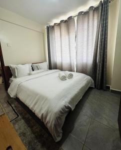 ein Schlafzimmer mit zwei Betten und einem Fenster in der Unterkunft Ikulu in Kisumu + 7 Fotos