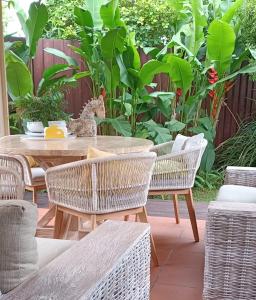a patio with a table and chairs and plants at Byron Bay Nest Homestay in Byron Bay