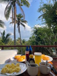 a table with food and drinks on a table with palm trees at Gading Tree House in Nusa Penida