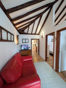 a living room with a red couch and a tv at CHC - Casa La Salvada - Los Silos in Los Silos