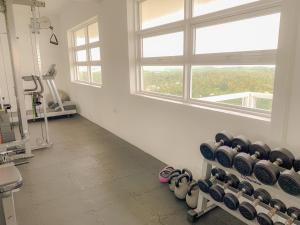a gym with a row of dumbbells in a room with a window at MaSa Beach Front harbour view penthouse D12 in Wattala