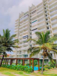瓦特勒Masa Beach Front Apartment D12的一座巨大的白色建筑，前面有棕榈树