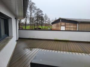 an empty patio with a wooden deck and a barn at FeWo Planck OG 3 SZ in Buxtehude