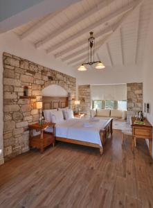 a bedroom with a large bed and a stone wall at Kose Konak Butik Hotel-Special in Alacati