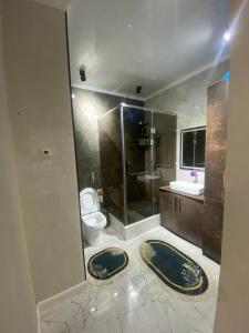 Un baño con inodoro, ducha y lavabo. en Royal apartment, en Shymkent