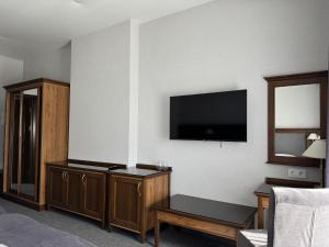a hotel room with a flat screen tv on the wall at Готель з басейном та сауною Горинський in Ryasniki