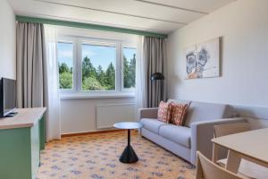 a living room with a couch and a table at IFA Schöneck Hotel & Ferienpark in Schöneck