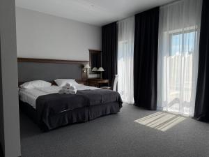 a bedroom with a bed with a stuffed animal on it at Готель з басейном та сауною Горинський in Ryasniki