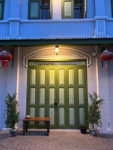 a green garage door with a bench in front of it at Mookda House Chinatown BKK near MRT Samyot in Khlong San