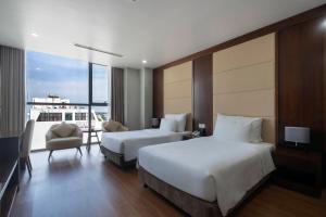 a hotel room with two beds and a balcony at Luxury6 Hotel in Móng Cái +5 photos