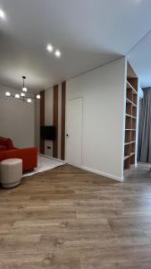 an empty living room with a couch and a door at Дизайнерская квартира рядом с Хан Шатыром in Astana