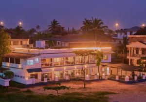a large building with lights on at night at Alleppey Holiday Beach Resort By VOYE HOMES in Alleppey