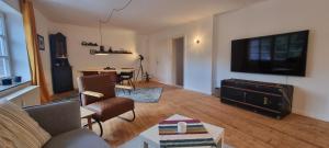 a living room with a couch and a flat screen tv at Zu Gast im Denkmal St Peter in Dormagen