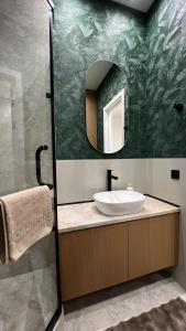 a bathroom with a sink and a mirror at Дизайнерская квартира рядом с Хан Шатыром in Astana