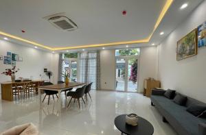 a living room with a couch and a table and chairs at Hotel Dell' Alba in Phú Quốc