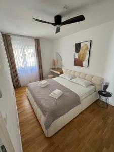 a bedroom with a large bed with a ceiling fan at Apartments Elin in Omiš
