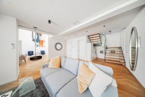 Una sala de estar con un sofá y una escalera. en The Grand Penthouse, en Viena